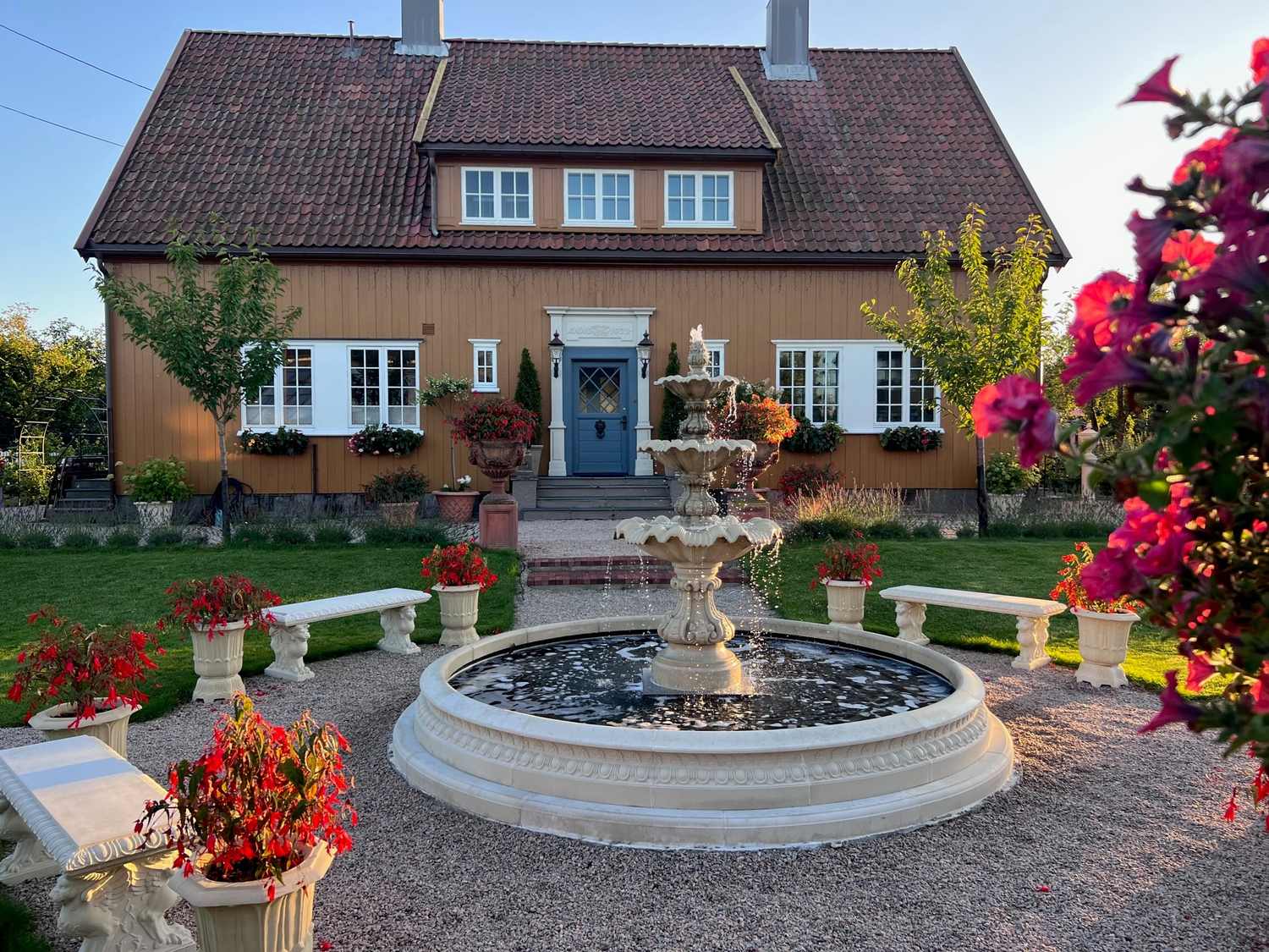 Den herskapelige villaen i Greåkerveien 149 med rund fontene og blomsterkrukker på gårdsplassen