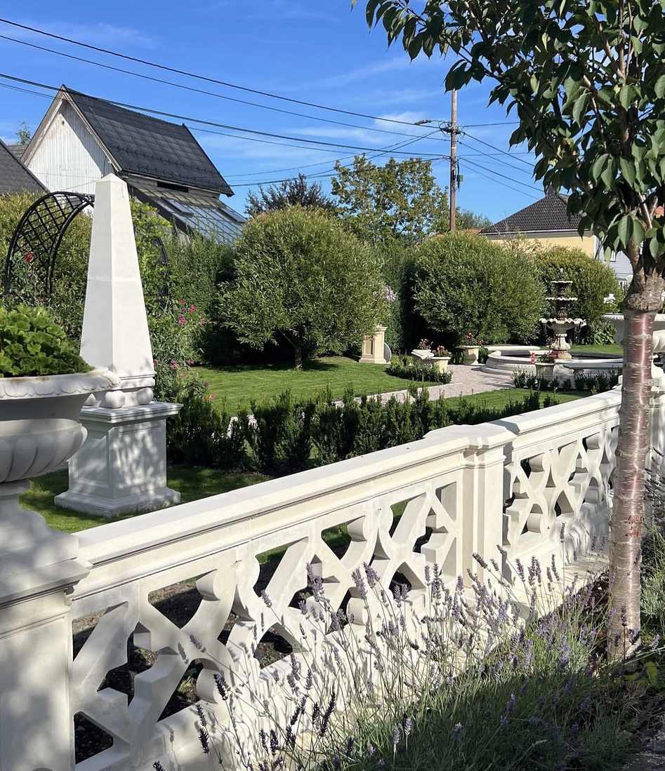Ferdig hageanlegg med hvit balustrade, klippede hekker og grusgang etter hageplan